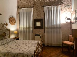 1 dormitorio con 1 cama y una ventana con cortinas en IL CASALE DEL VINO, en Barbarano Vicentino