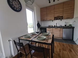 eine Küche mit einem Tisch mit Stühlen und einer Uhr an der Wand in der Unterkunft Apartman 982 Divčibare in Divčibare