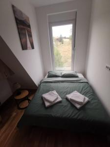 ein Schlafzimmer mit einem Bett mit zwei Handtüchern darauf in der Unterkunft Apartman 982 Divčibare in Divčibare