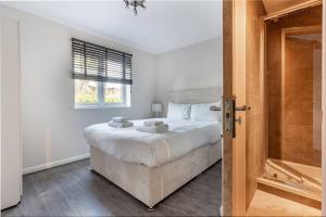 雷迪奇的住宿－Lovely 2bed Apt in Redditch, Free Wi-Fi & Parking，白色的卧室设有床和窗户