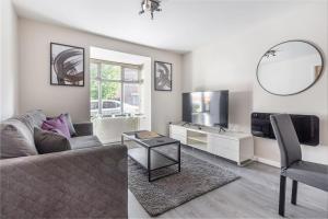 a living room with a couch and a tv and a mirror at Lovely 2bed Apt in Redditch, Free Wi-Fi & Parking in Redditch
