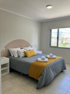 a bedroom with a large bed with towels on it at Laguna Pampa in Chascomús