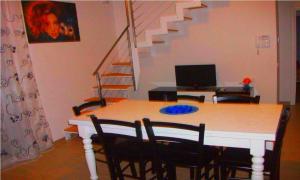 a dining room with a table with chairs and a staircase at Holiday Home Michela in Milano Marittima