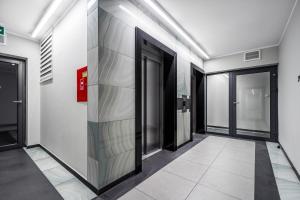 a hallway of an office building with glass doors at Apartament Kasprzaka Bliska Wola in Warsaw