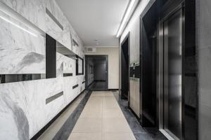 a hallway with black and white marble walls at Apartament Kasprzaka Bliska Wola in Warsaw
