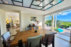 Un comedor con mesa y sillas de madera. en Villa Bel'Vue tout a pied, a 350 m de la plage, en Orient Bay
