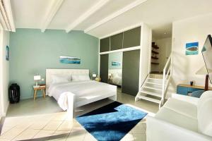 Un dormitorio con una cama blanca y una escalera. en Villa Bel'Vue tout a pied, a 350 m de la plage, en Orient Bay 43 fotos más