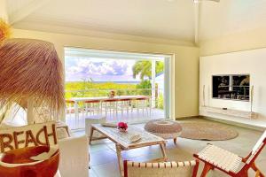 Una sala de estar con chimenea y una mesa y sillas. en Villa Bel'Vue tout a pied, a 350 m de la plage, en Orient Bay