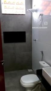 a bathroom with a white toilet and a sink at Área de laser Gabata in Delfinópolis