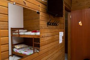 a room with two bunk beds and a television at Pousada Tio Bilia in Imbituba