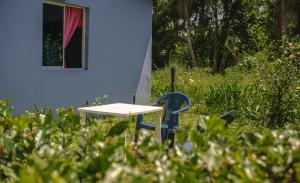 einen Tisch und einen Stuhl vor einem blauen Haus in der Unterkunft Cabañas yami in Playa Ladrilleros