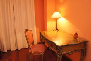 Zimmer mit einem Tisch, einer Lampe und einem Stuhl in der Unterkunft La Hosteria de Castroviejo in Duruelo de la Sierra