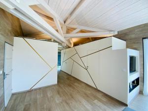 Cette chambre est dotée de murs blancs et d'un plafond en bois. dans l'établissement Artik chalet avec vue à 180 degrés et piscine, aux Angles