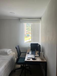 1 dormitorio con escritorio, ordenador portátil y cama en Habitación en apartamento Robledo-Medellin, en Medellín