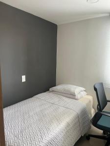 1 dormitorio con 1 cama y 1 silla en Habitación en apartamento Robledo-Medellin, en Medellín