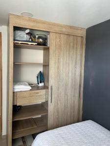 1 dormitorio con armario de madera y cama en Habitación en apartamento Robledo-Medellin, en Medellín