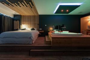 a bedroom with a large bed and a bath tub at Loveroom Lens in Lens