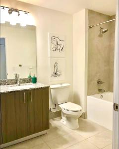 a bathroom with a toilet and a sink and a tub at Doral City View in Miami