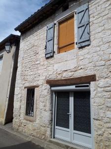 a stone building with a door and windows at la maison de Juliette En bas in Lascabanes