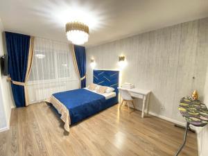 1 dormitorio con cama azul y escritorio en ЖК Лето новая однокомнатная квартира, en Astana