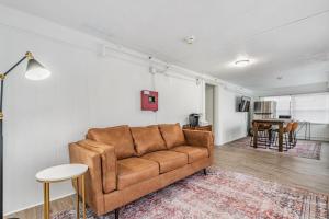 - un salon avec un canapé brun et une table dans l'établissement Satoshi Hideout Living - Rooms & Studios, à St Petersburg