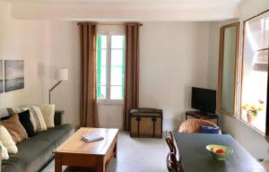 a living room with a couch and a table at Maison de charme en bord de Mer in Le Barcarès