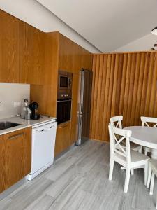 a kitchen with wooden walls and a table and chairs at Mike’s House in Lourinhã