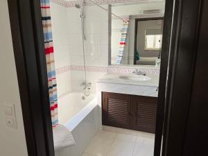Un baño con lavabo, bañera y espejo. en House´s Golf, en Almancil 13 fotos más