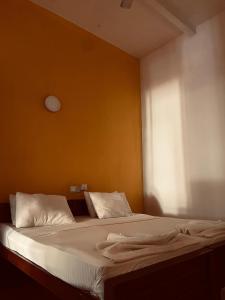 - une chambre avec un lit doté de draps blancs et une fenêtre dans l'établissement Fortuna Heritage Home, à Kandy