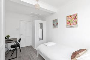 a white bedroom with a bed and a desk at Modern Two Bedroom Apartment with Free Parking! in London