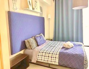 マイアミにあるDoral Skyline 2Bのベッドルーム1室(ブルーヘッドボード付きのベッド1台付)