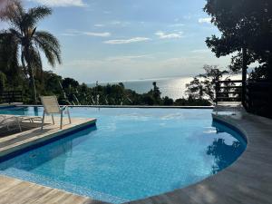 a swimming pool with a view of the ocean at BELÍSSIMA CASA ILHABELA in Ilhabela