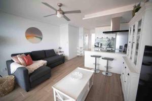 a living room with a couch and a kitchen at Renovated apartment in La Manga with great sunset in La Manga del Mar Menor