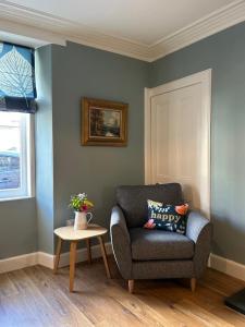 un soggiorno con sedia e tavolo di The Fiddich Luxury Home in Craigellachie a Craigellachie