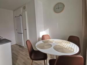 tavolo e sedie bianchi in cucina con orologio di Rovaniemi Cityhome Pekankatu a Rovaniemi