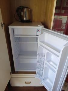 an open refrigerator with a microwave sitting on top of it at Apartment Unforgetable Gardens in Falmouth