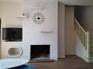 a white brick fireplace with a tv on top of it at Maison centre Connerré - Proche 24h - 11 pers - 4 chambres in Connerré