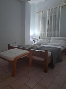a bedroom with two beds and a bench in it at dreamcatcher in Anavyssos