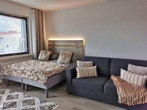 un soggiorno con un divano blu e un letto di Rovaniemi Cityhome Pekankatu a Rovaniemi