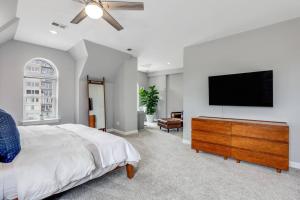 a bedroom with a bed and a flat screen tv at The Lumber Baron's Penthouse 3BR / 2.5 BA in Detroit