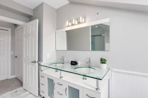 a bathroom with a glass sink and a mirror at The Lumber Baron's Penthouse 3BR / 2.5 BA in Detroit