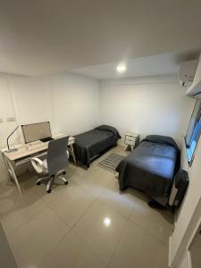 a hospital room with two beds and a desk at Apartamento 2 habitaciones Pichincha in Rosario