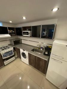 a kitchen with a white refrigerator and a sink at Apartamento 2 habitaciones Pichincha in Rosario