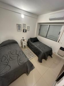 a bedroom with two beds and a window at Apartamento 2 habitaciones Pichincha in Rosario