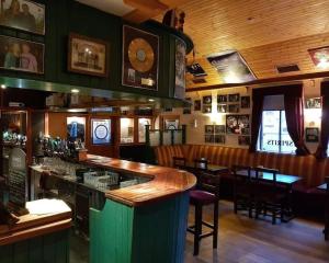 eine Bar in einem Restaurant mit Tischen und Stühlen in der Unterkunft Spacious Cottage in Meenaleck near Gweedore County Donegal in Donegal