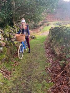 a woman riding a bike down a path at Spacious Cottage in Meenaleck near Gweedore County Donegal in Donegal