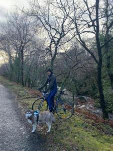 una persona in bicicletta con un cane su un sentiero di Spacious Cottage in Meenaleck near Gweedore County Donegal a Donegal
