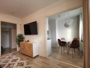 un soggiorno con tavolo, sedie e televisione di Rovaniemi Cityhome Pekankatu a Rovaniemi