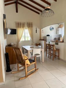 a kitchen and living room with a table and chairs at Bambou - Gîte du moulin in Petit-Canal