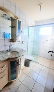 y baño con aseo, lavabo y ducha. en Residencial Kremer, en Florianópolis